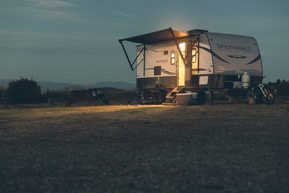 a small camper sits in a field at night