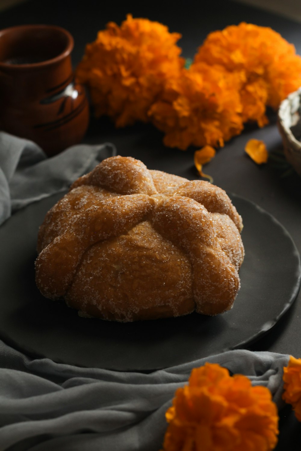 une assiette avec une pâtisserie dessus à côté de quelques fleurs