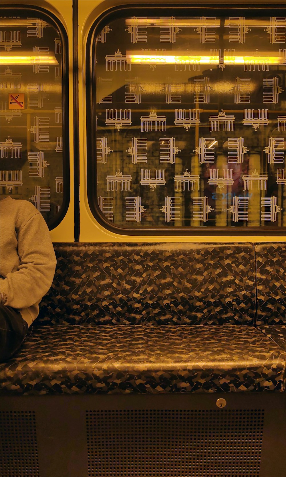 Un uomo seduto su una panchina davanti a una finestra