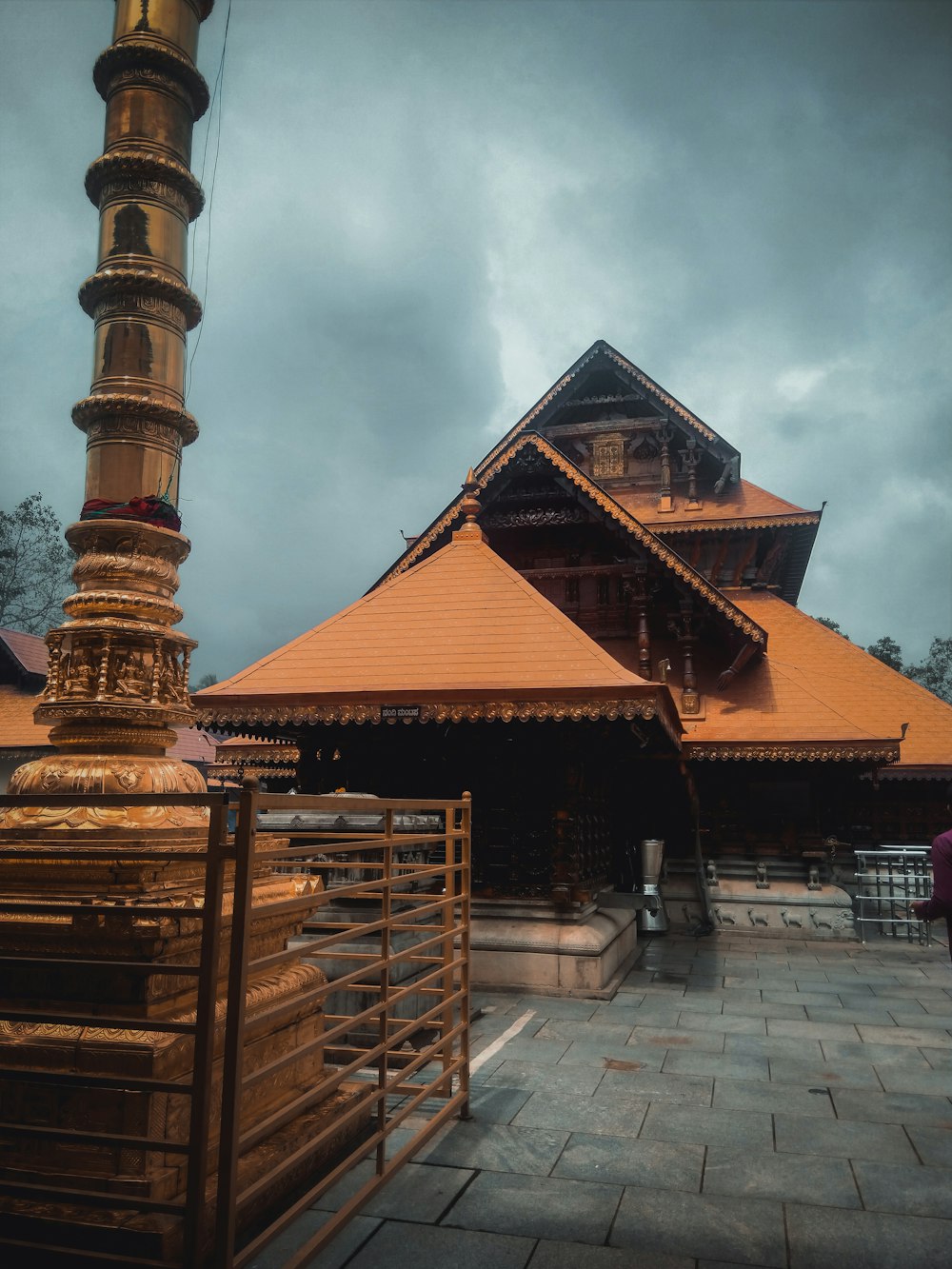 a tall building with a golden roof on a cloudy day