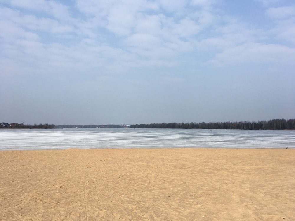 a sandy beach with a body of water in the distance