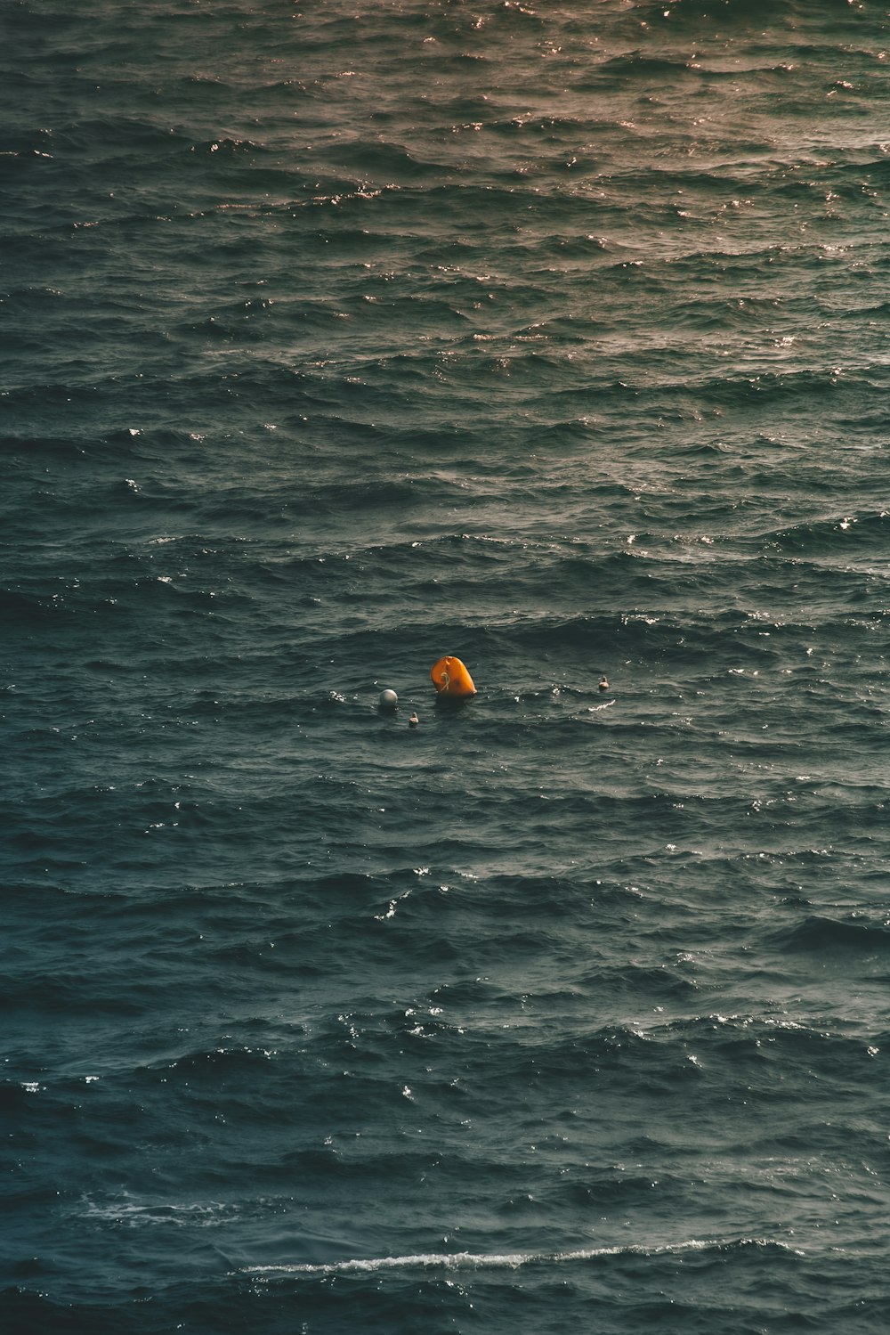 a yellow object floating in the middle of the ocean