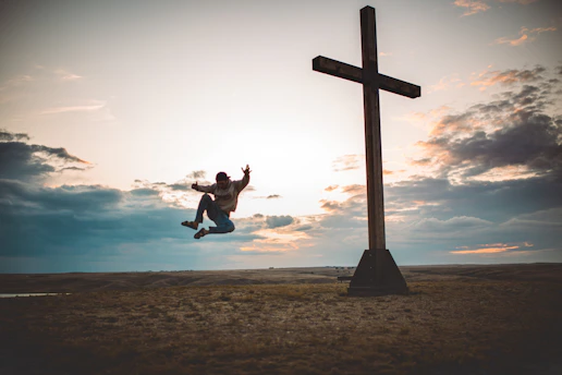 A dynamic scene of Jesus Run character performing a parkour jump over urban rooftops at sunset in Tenerife.