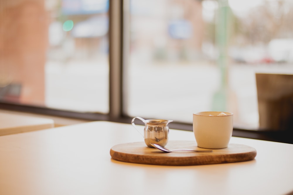 a cup of coffee sitting on top of a wooden table