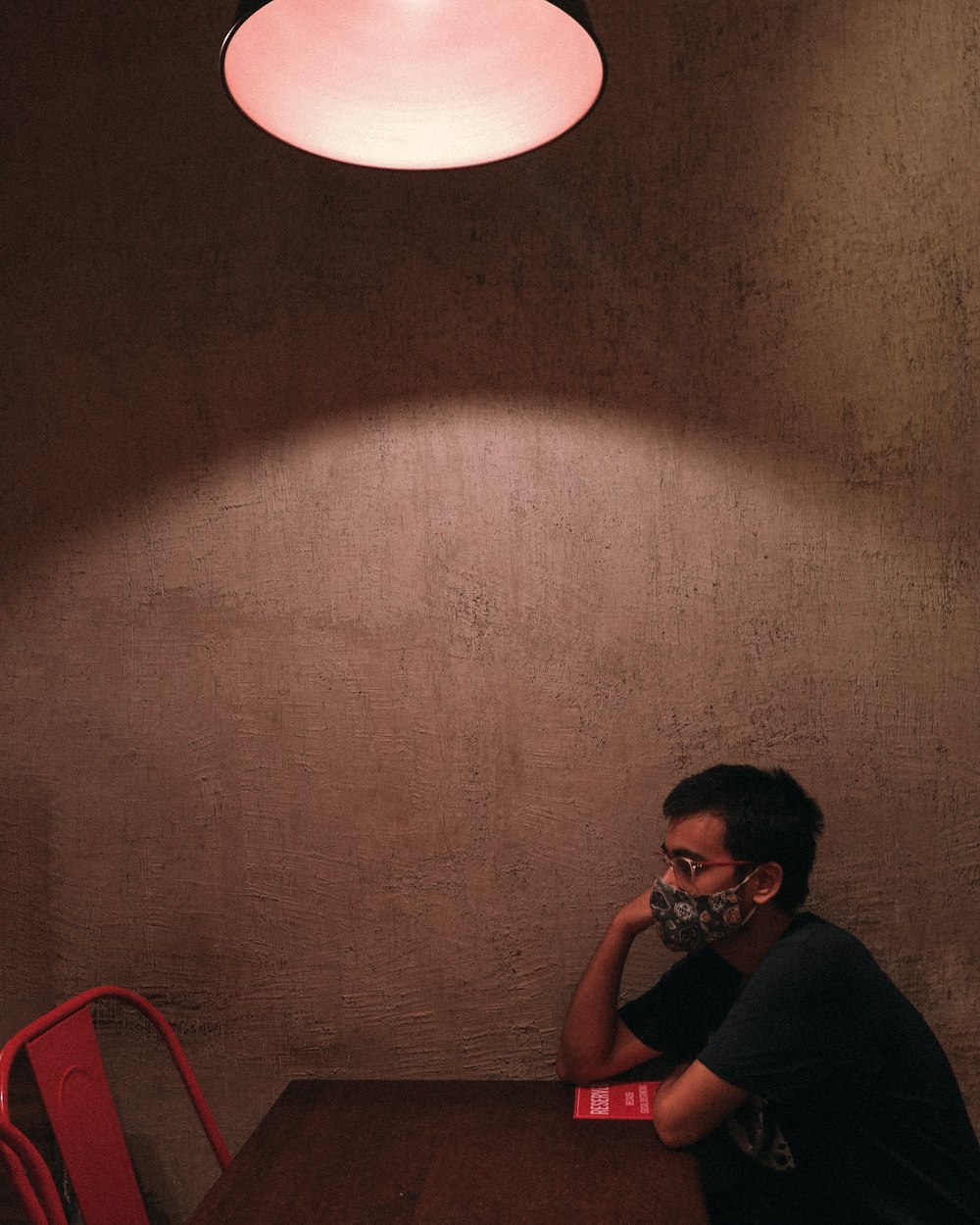 a man sitting at a table with a mask on his face