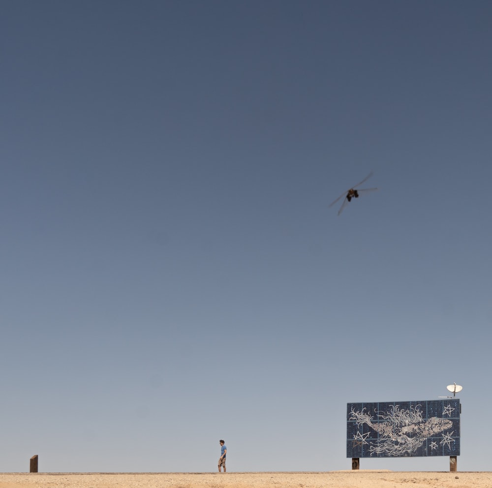 a kite flying in the sky above a sign