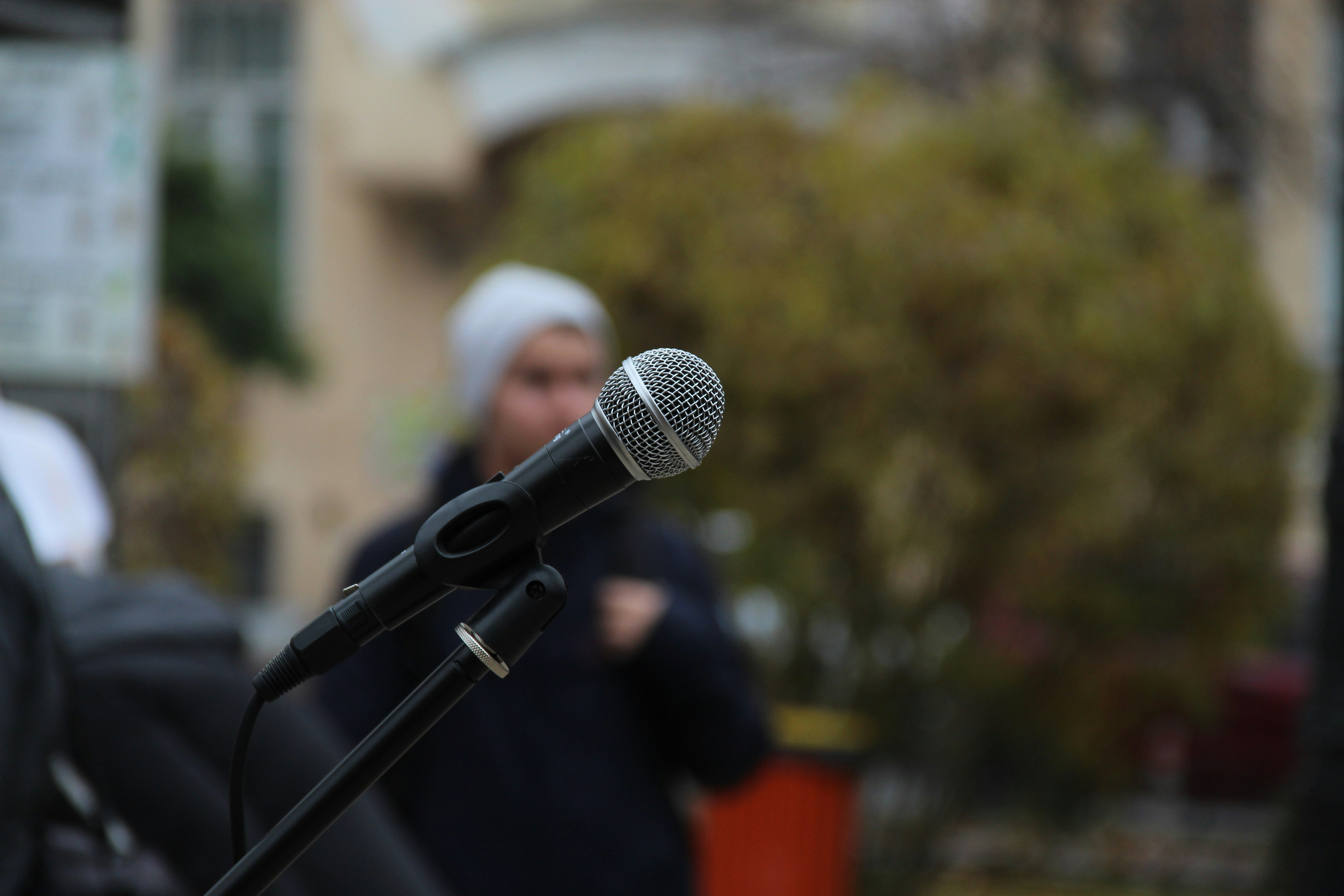 Donald Trump speaking at a political rally, passionately addressing a crowd with microphones in front of him