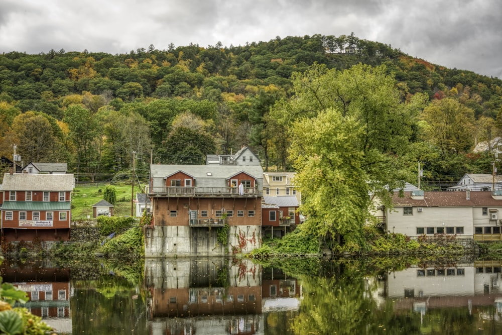 a scenic view of a small town with a lake in front of it