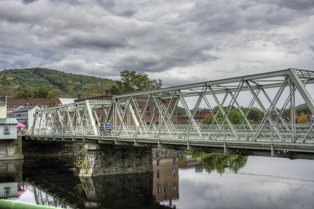 a bridge over a body of water with buildings in the background