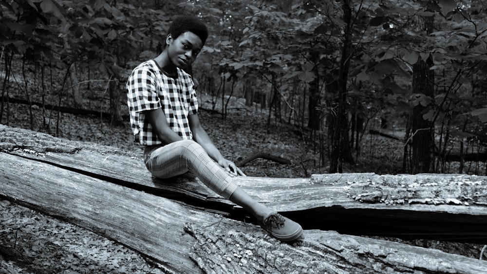 a man sitting on a log in the woods