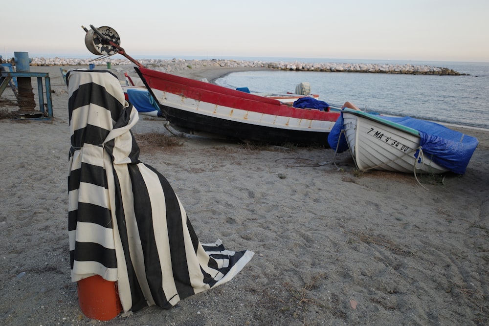 a woman standing on a beach next to boats