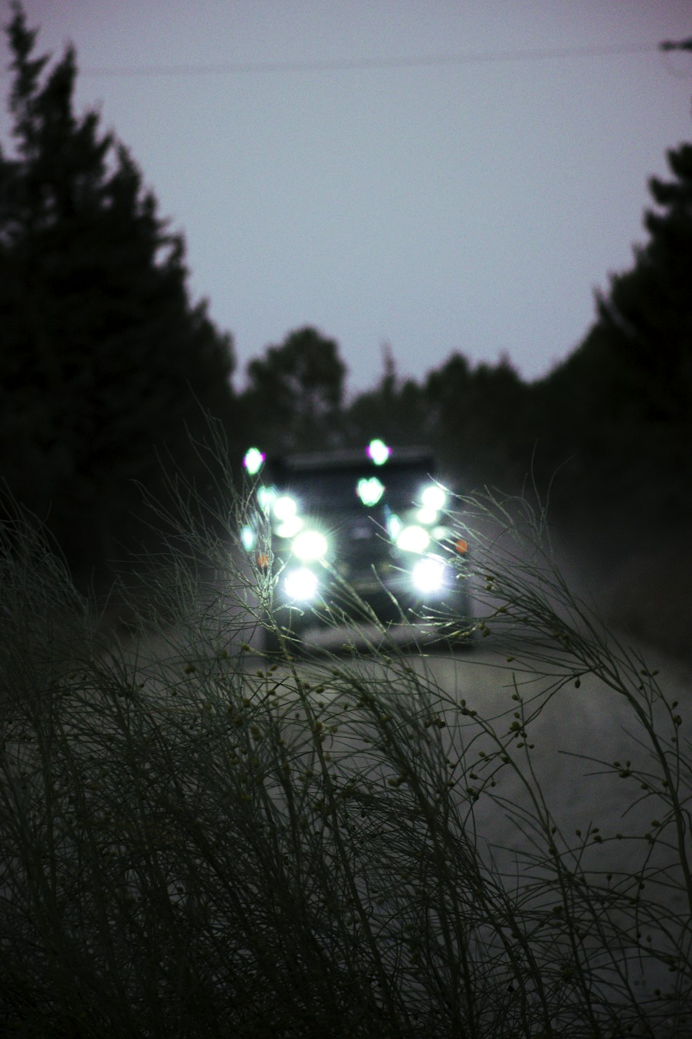 a couple of cars driving down a road at night