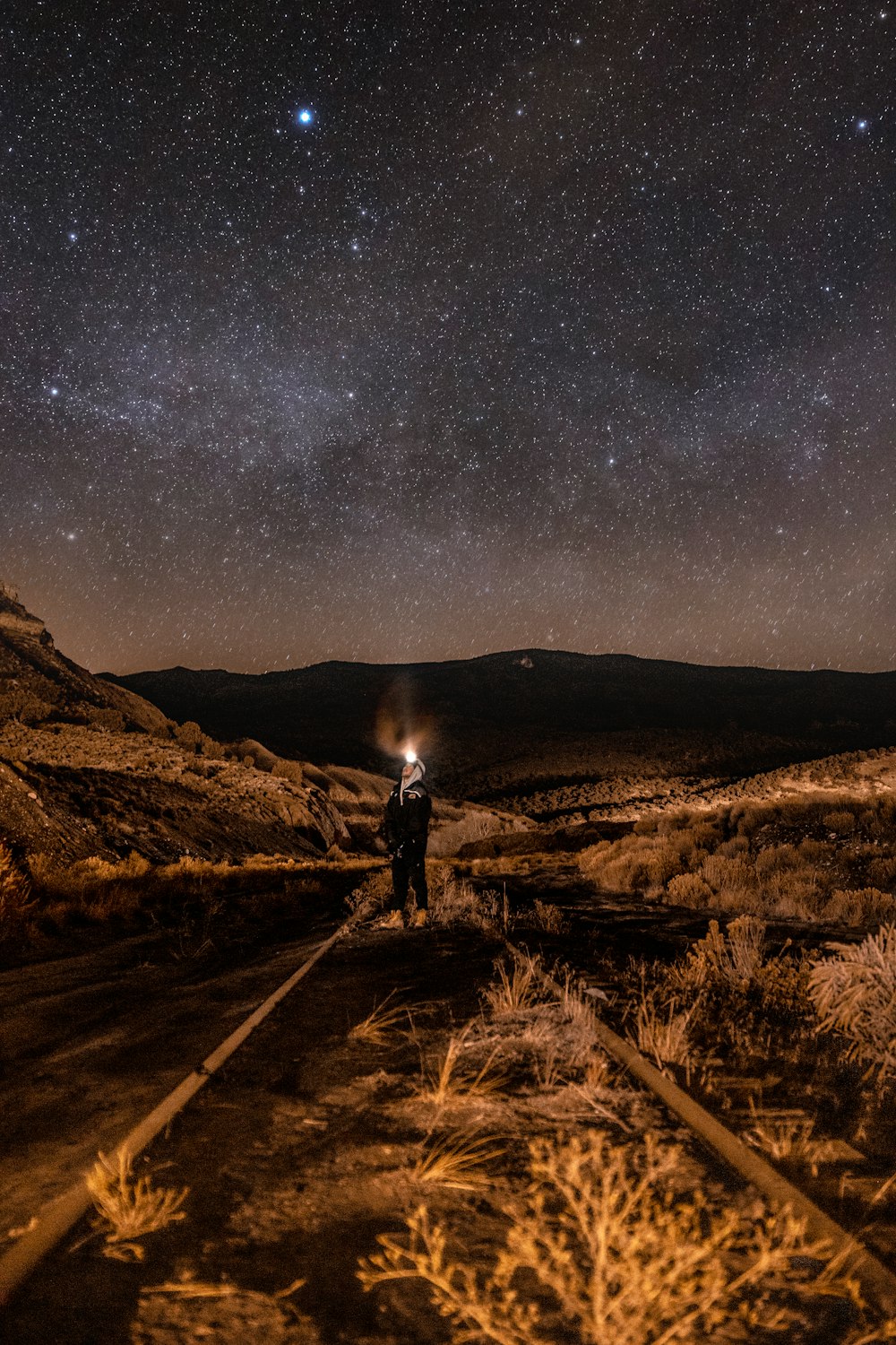 a person standing on a train track at night