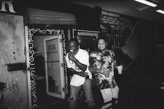 A small business storefront with customers interacting and smiling outside.