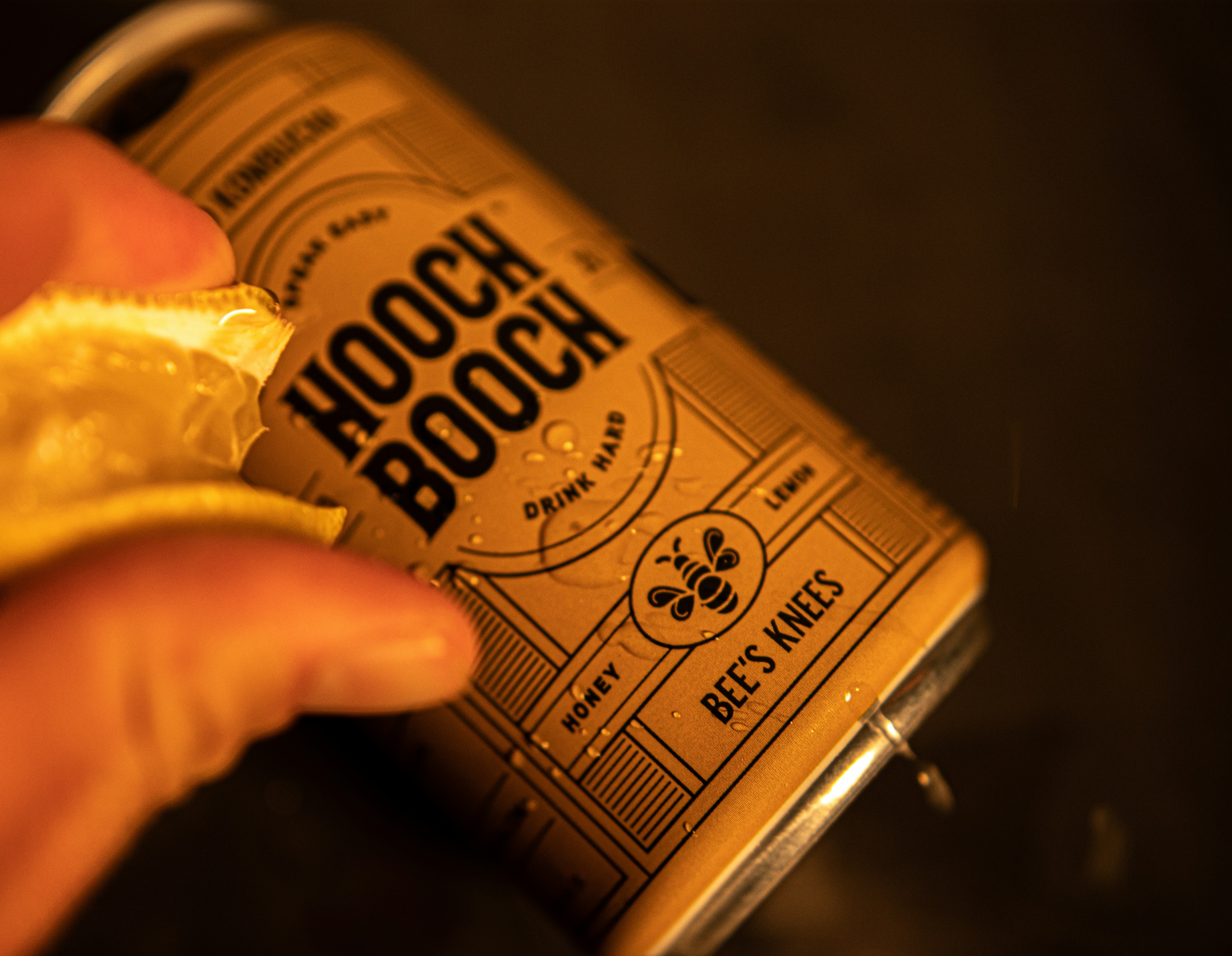 a person holding a can of boochat with a bite taken out of it