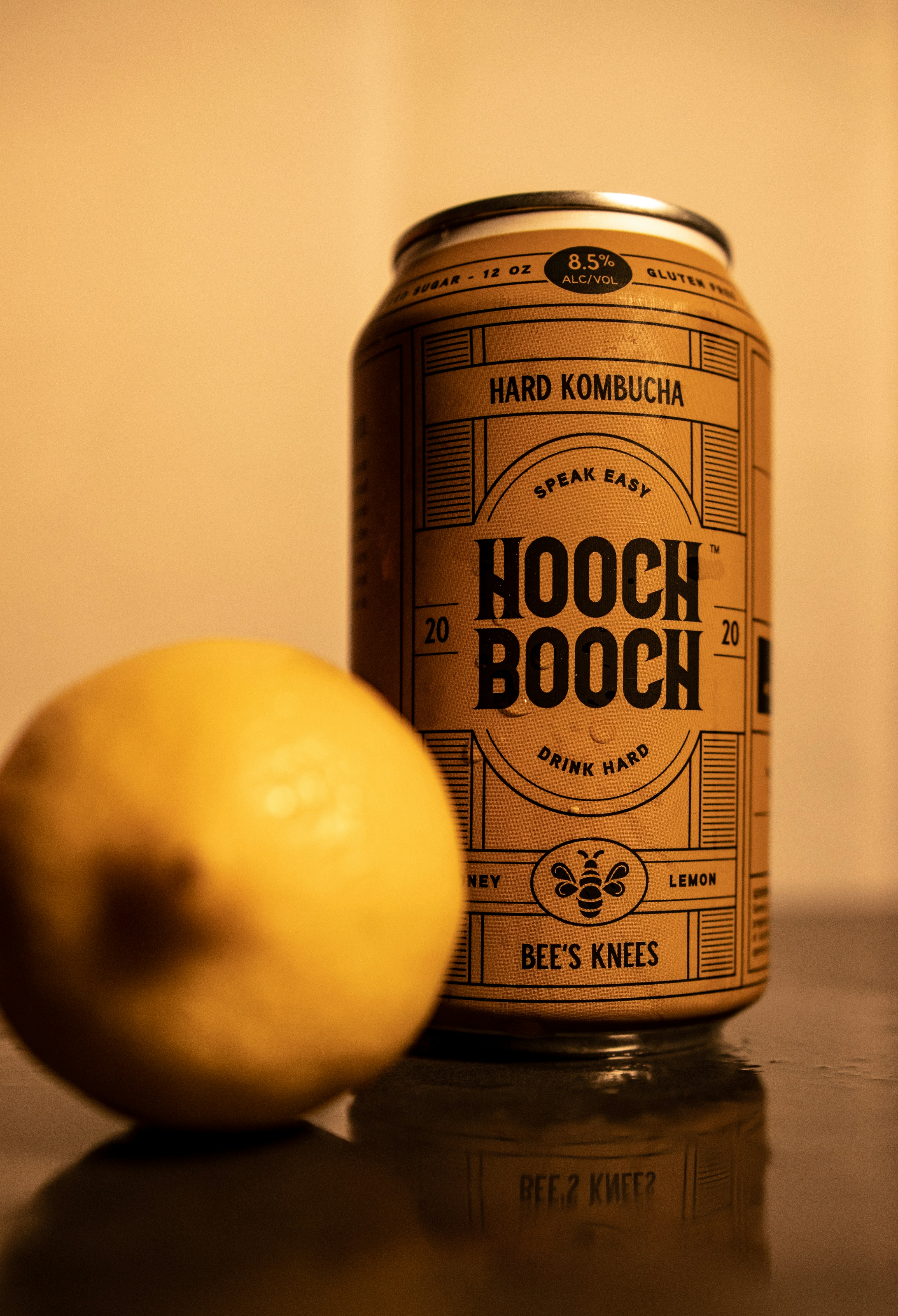 a can of beer next to a lemon on a table
