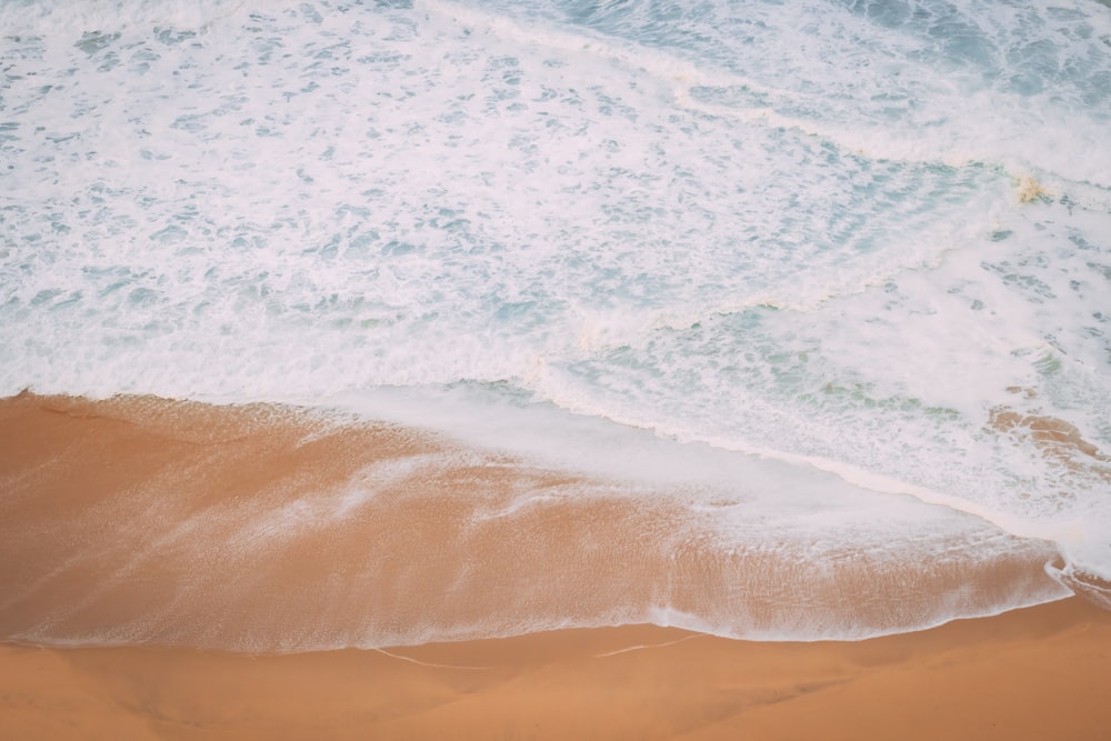 a view of the ocean from above of a sandy beach