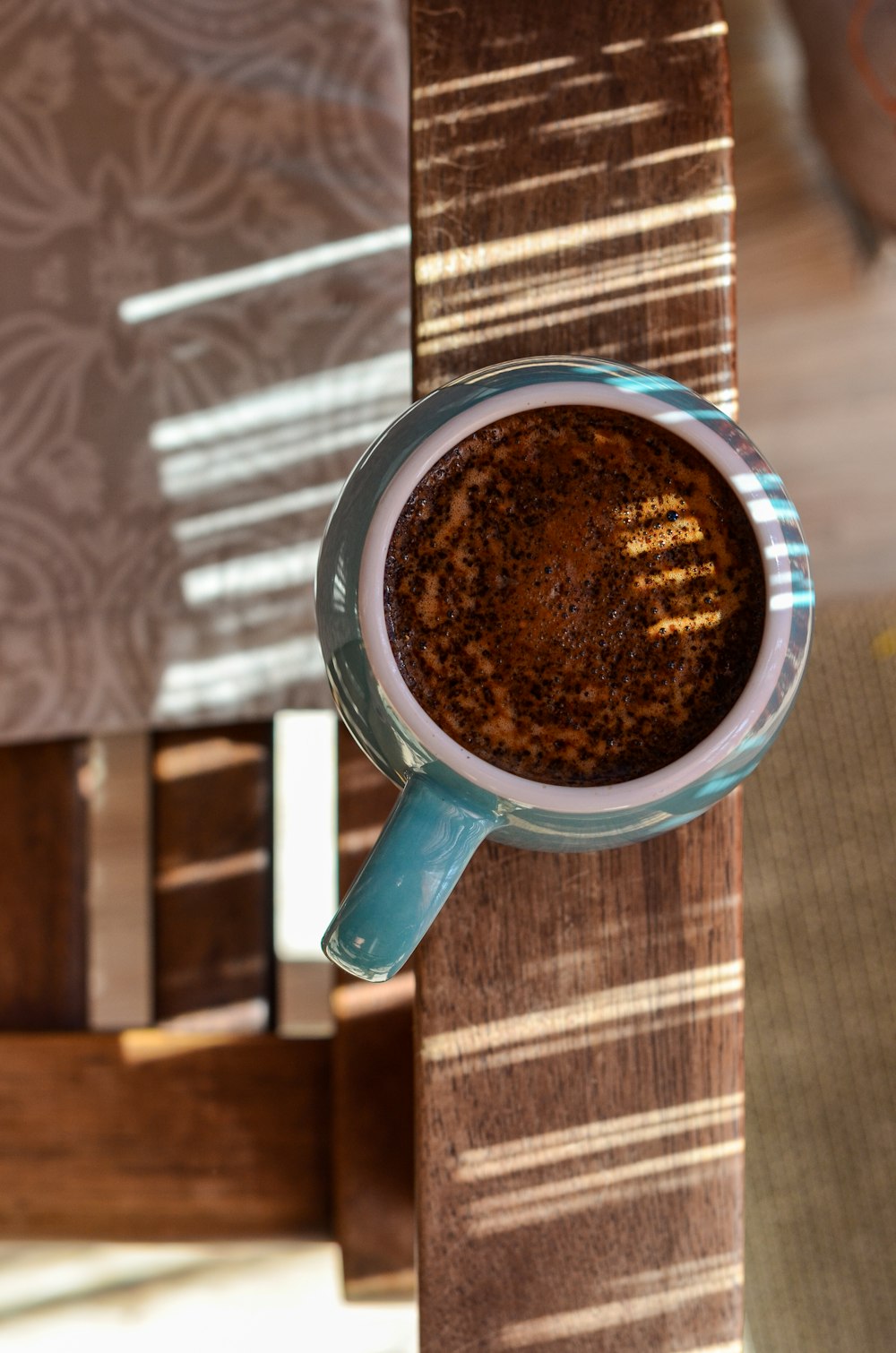 a cup of coffee sitting on top of a wooden table