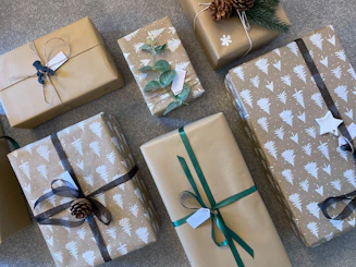 A colorful assortment of gift boxes and bags arranged on a wooden table with ribbons and tags.