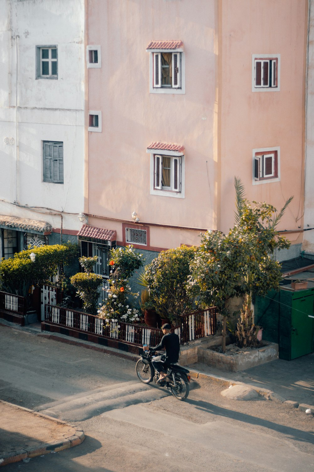 a man riding a bike down a street next to tall buildings