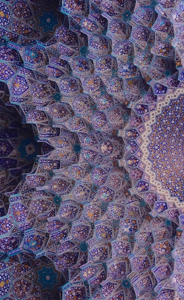 an intricate blue and purple pattern on the ceiling of a building