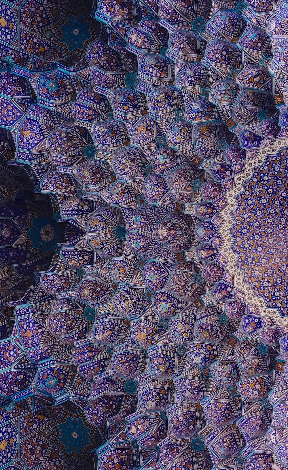an intricate blue and purple pattern on the ceiling of a building