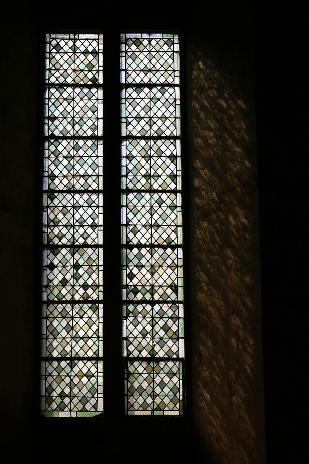 two stained glass windows in a dark room