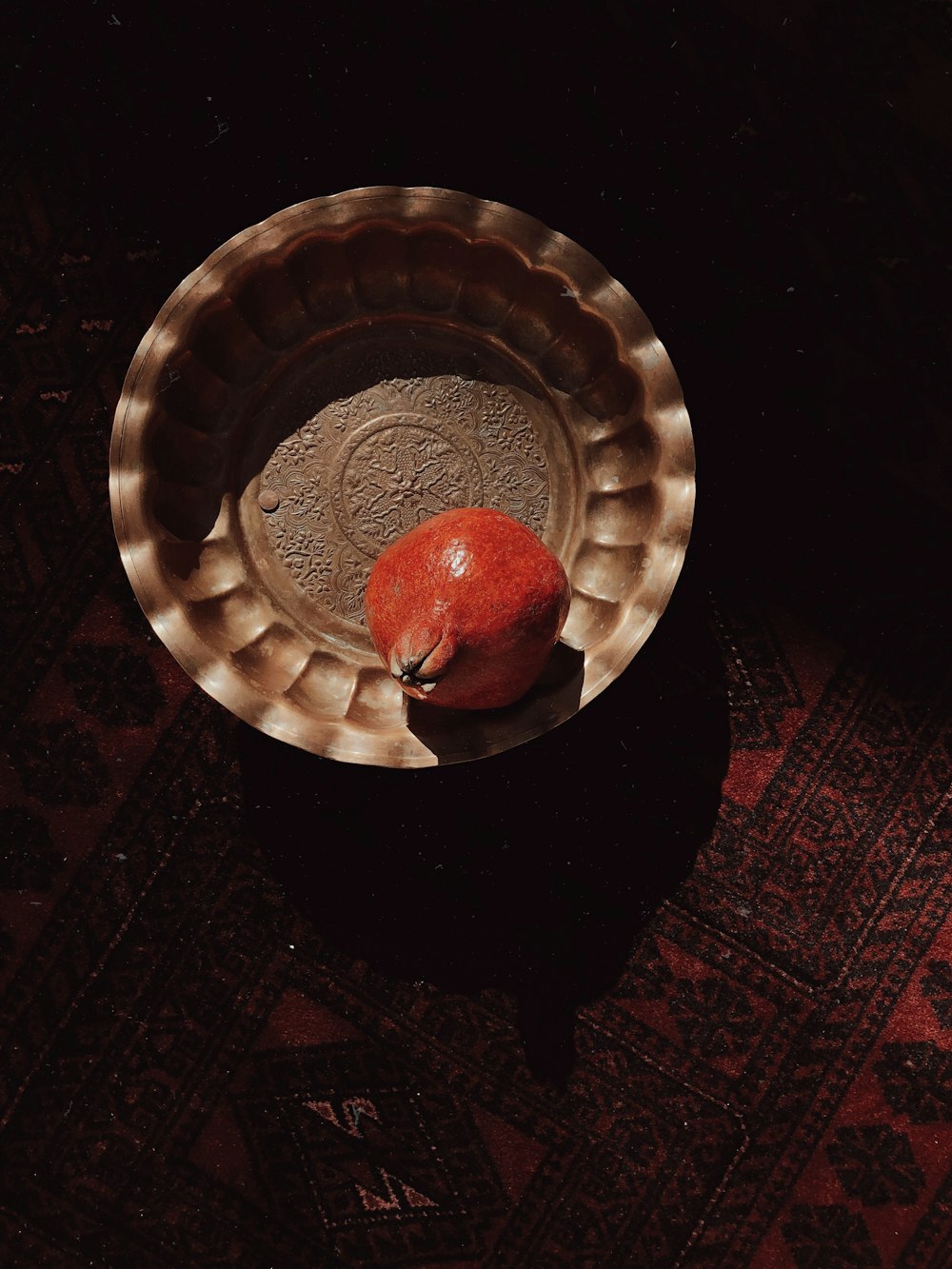 a red apple sitting in a bowl on a table