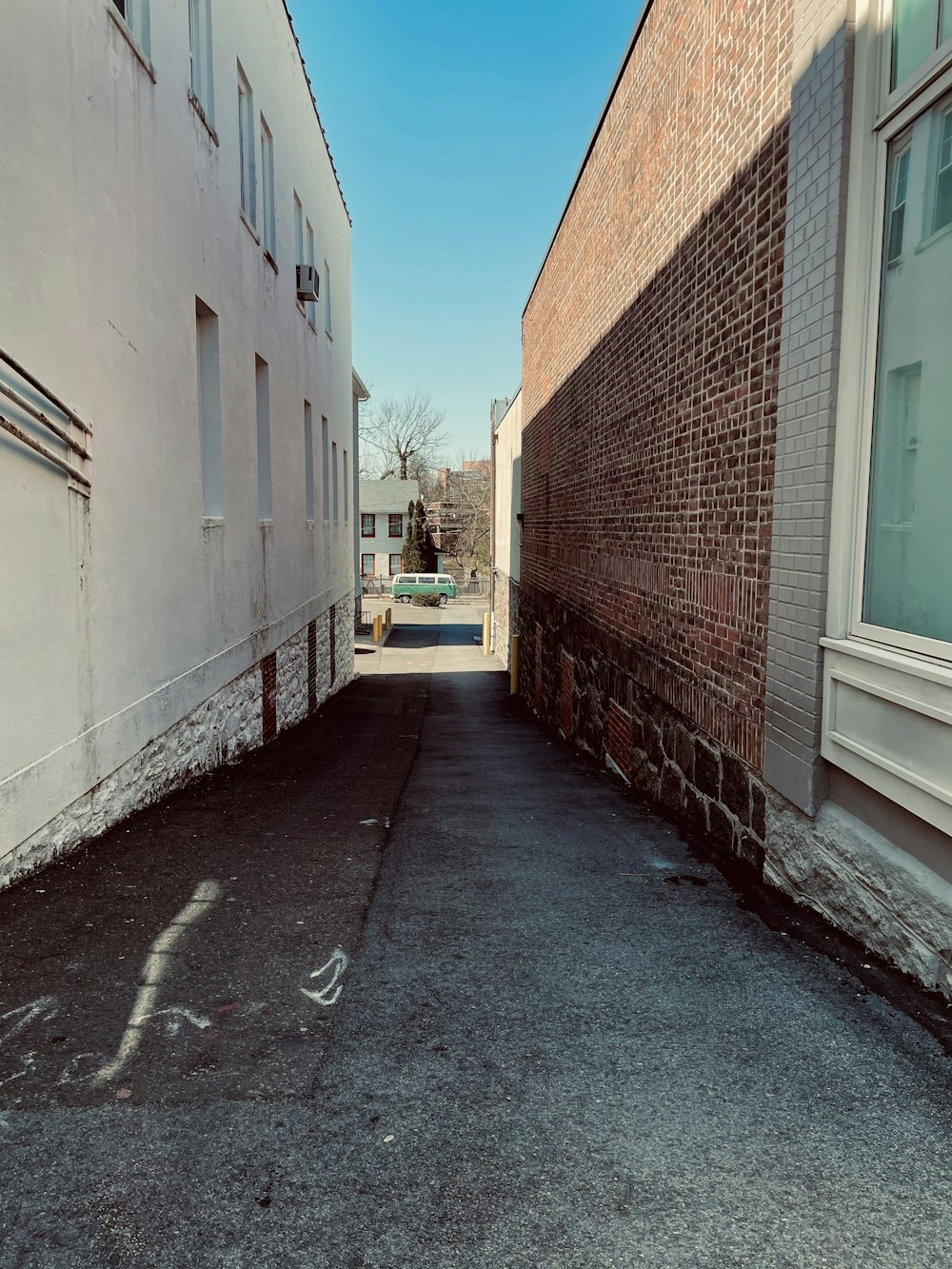 a narrow alley between two buildings with a blue sky in the background