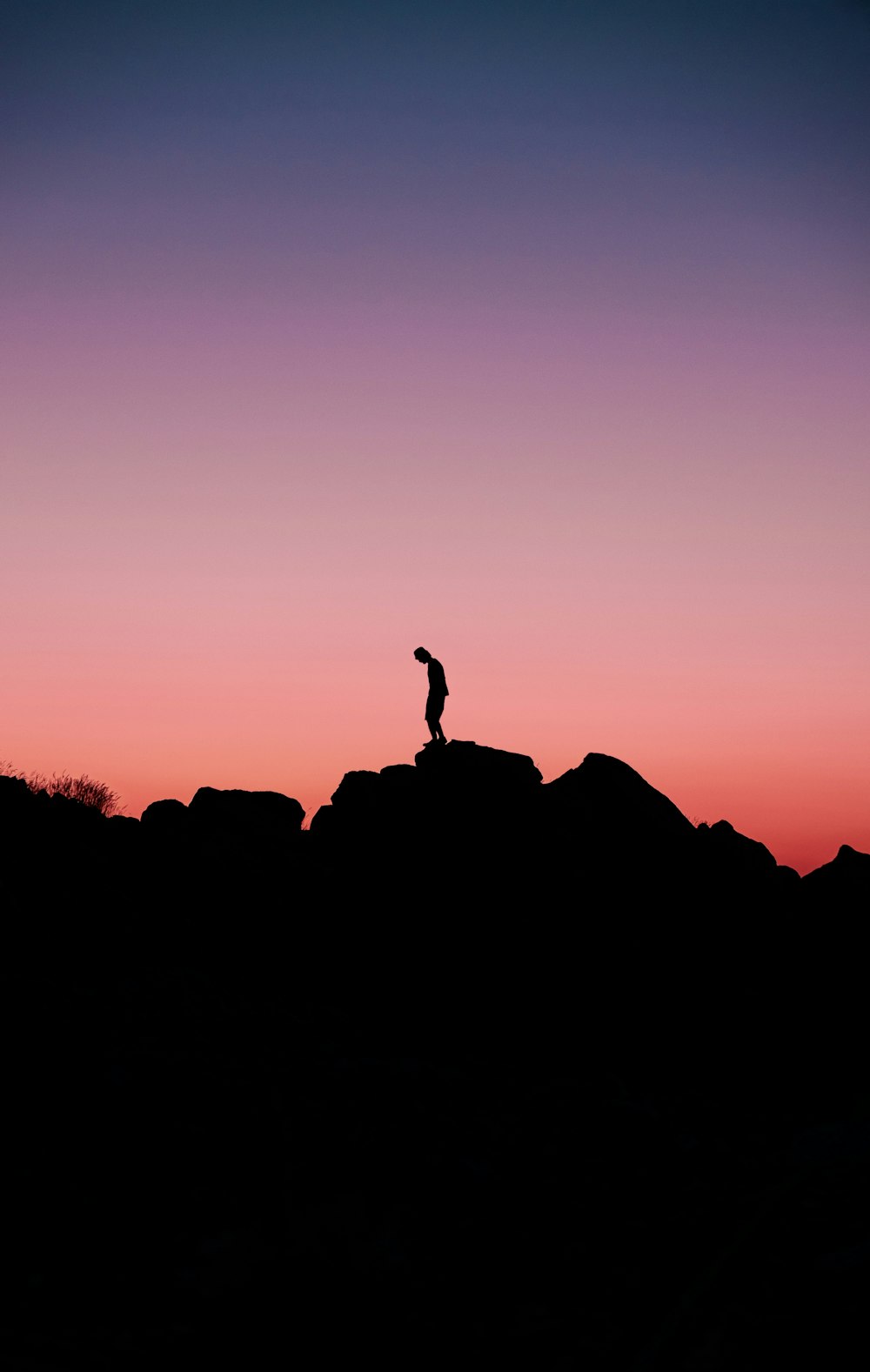 a person standing on top of a large rock