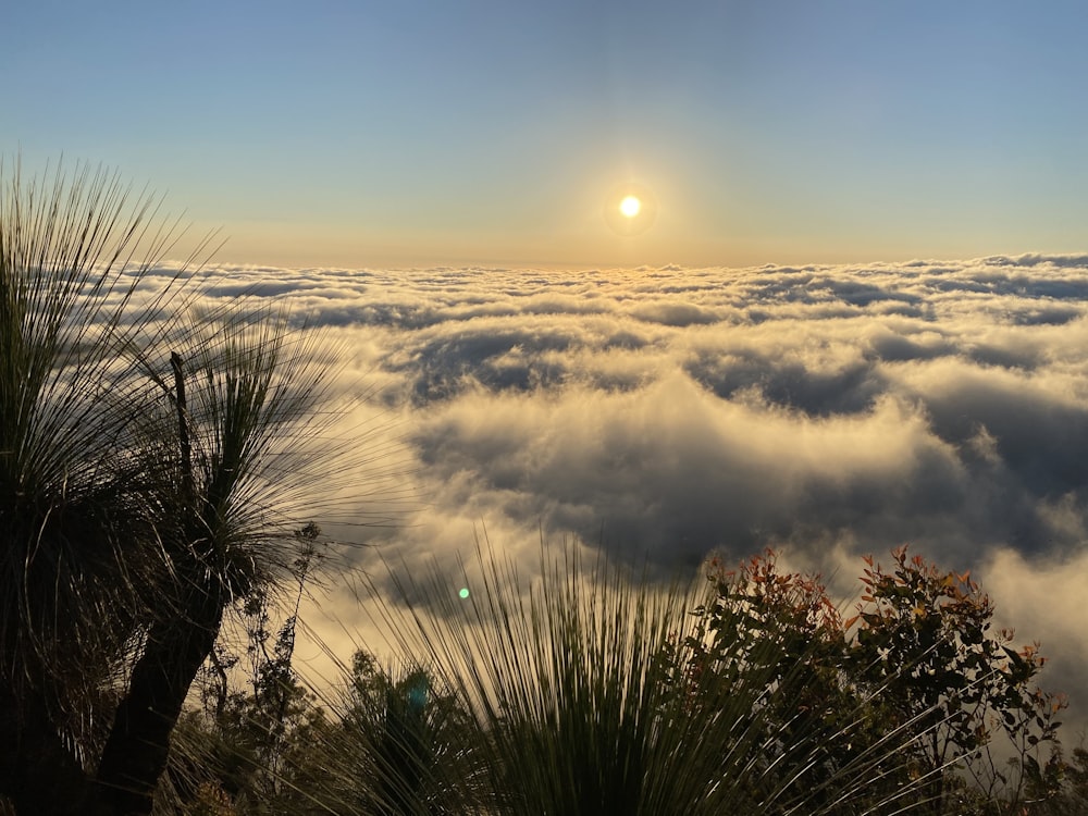 the sun is shining above the clouds in the sky