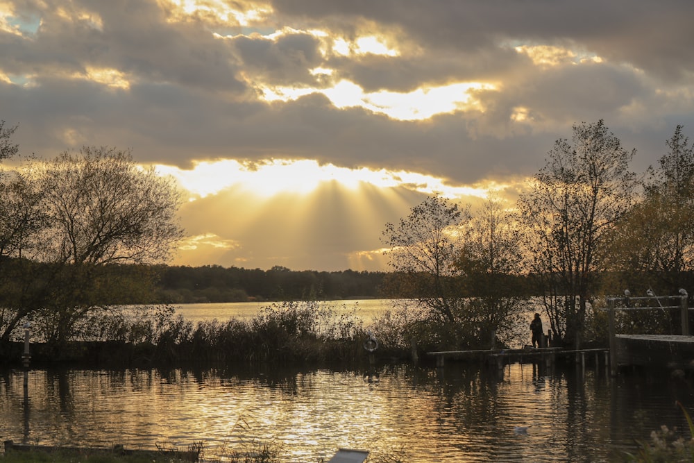 the sun is shining through the clouds over the water