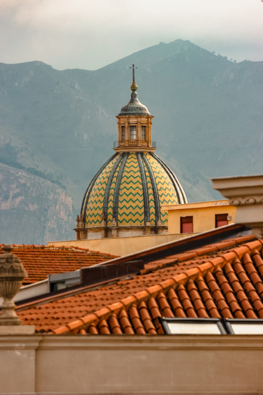 a view of a building with a dome and mountains in the background