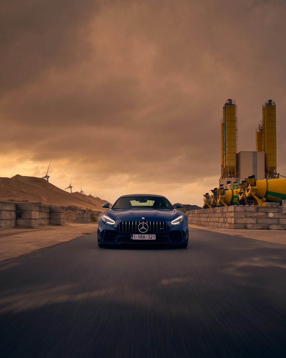 a blue sports car driving down a road