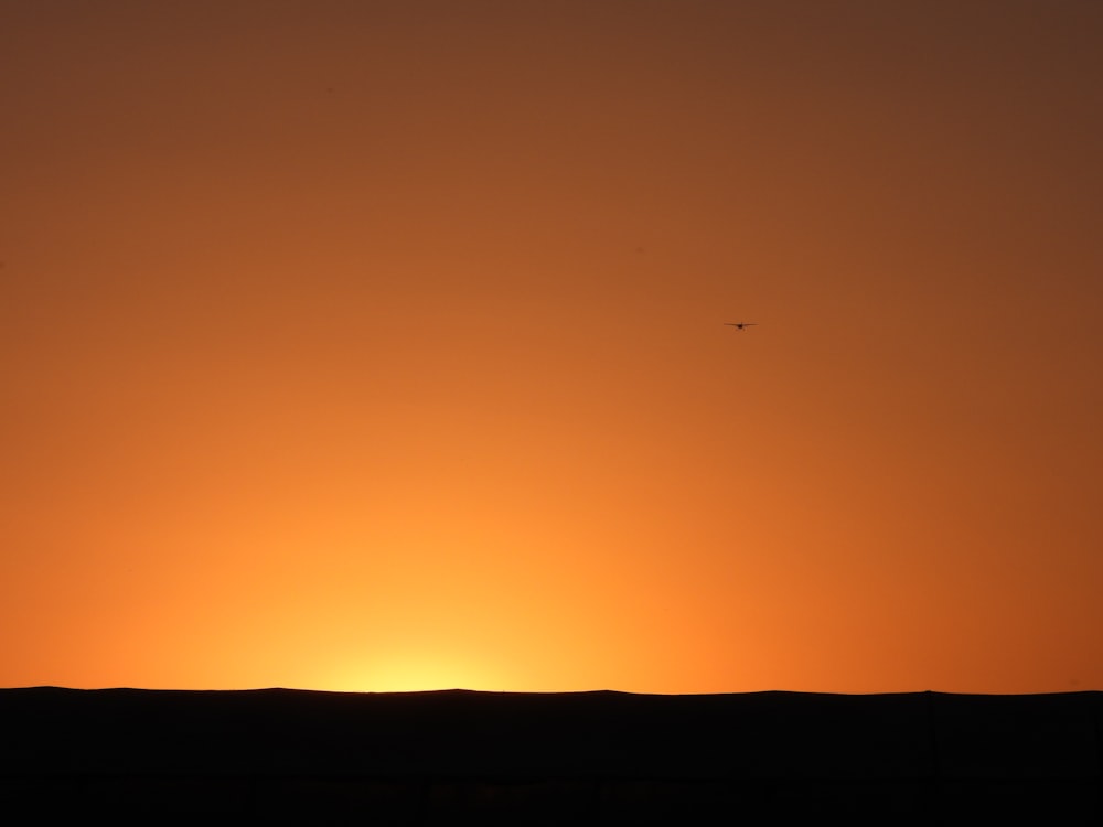 the sun is setting over the horizon of the desert