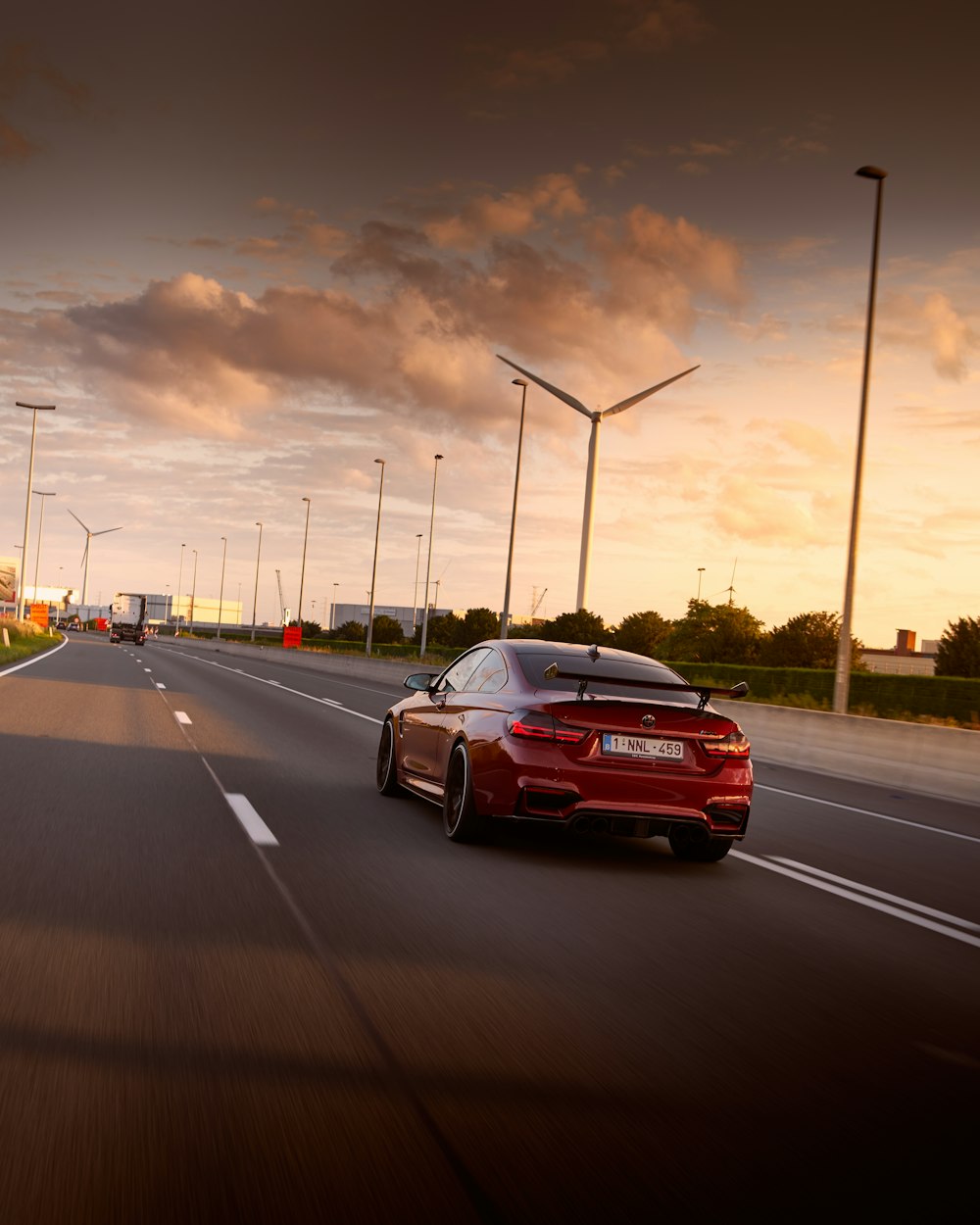 a red sports car driving down a highway