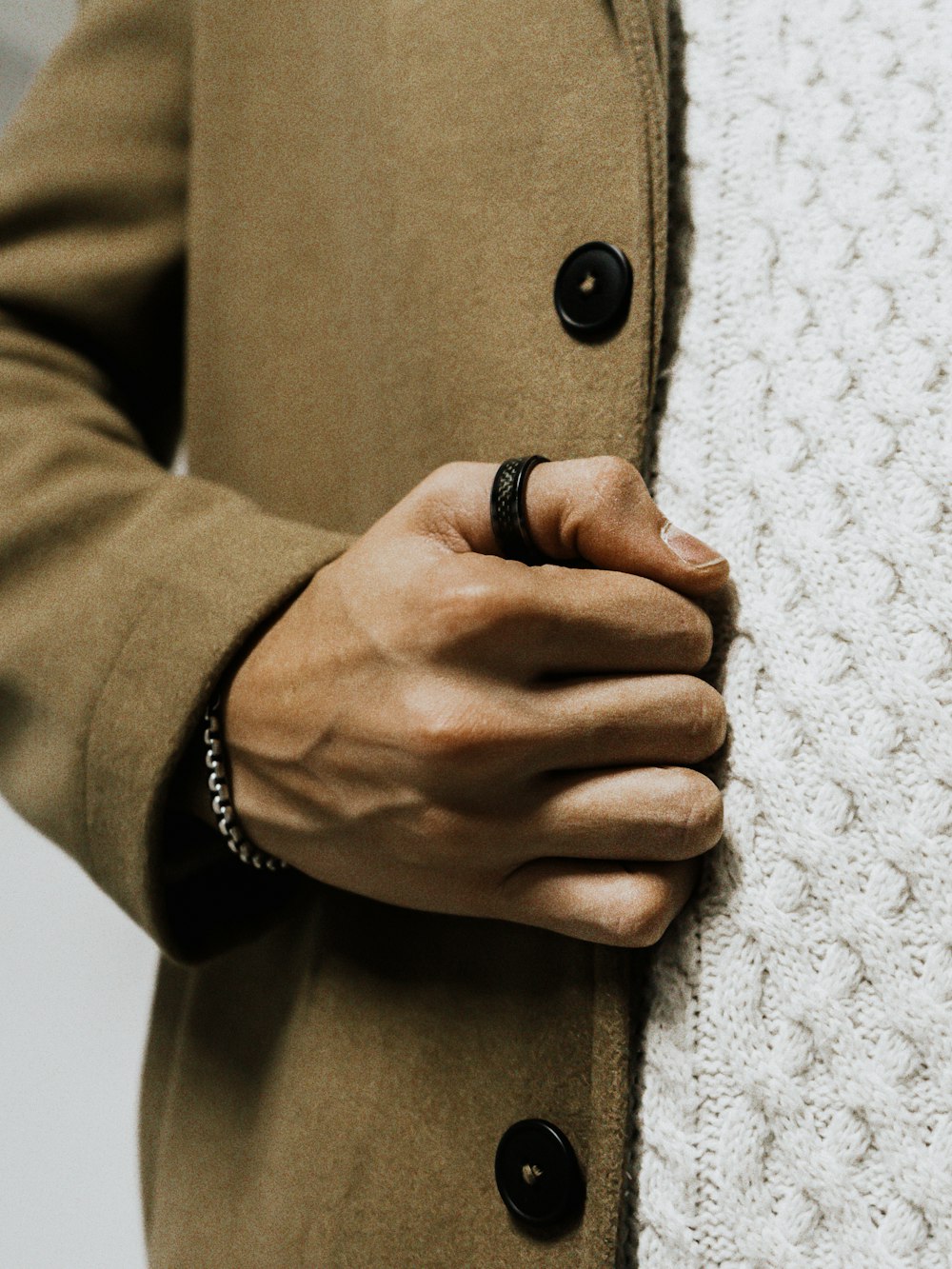 a person wearing a ring and a coat