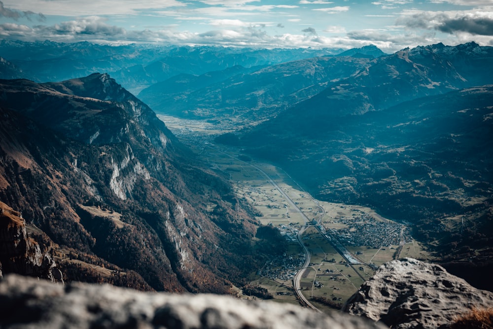 a view of a valley and mountains from the top of a mountain