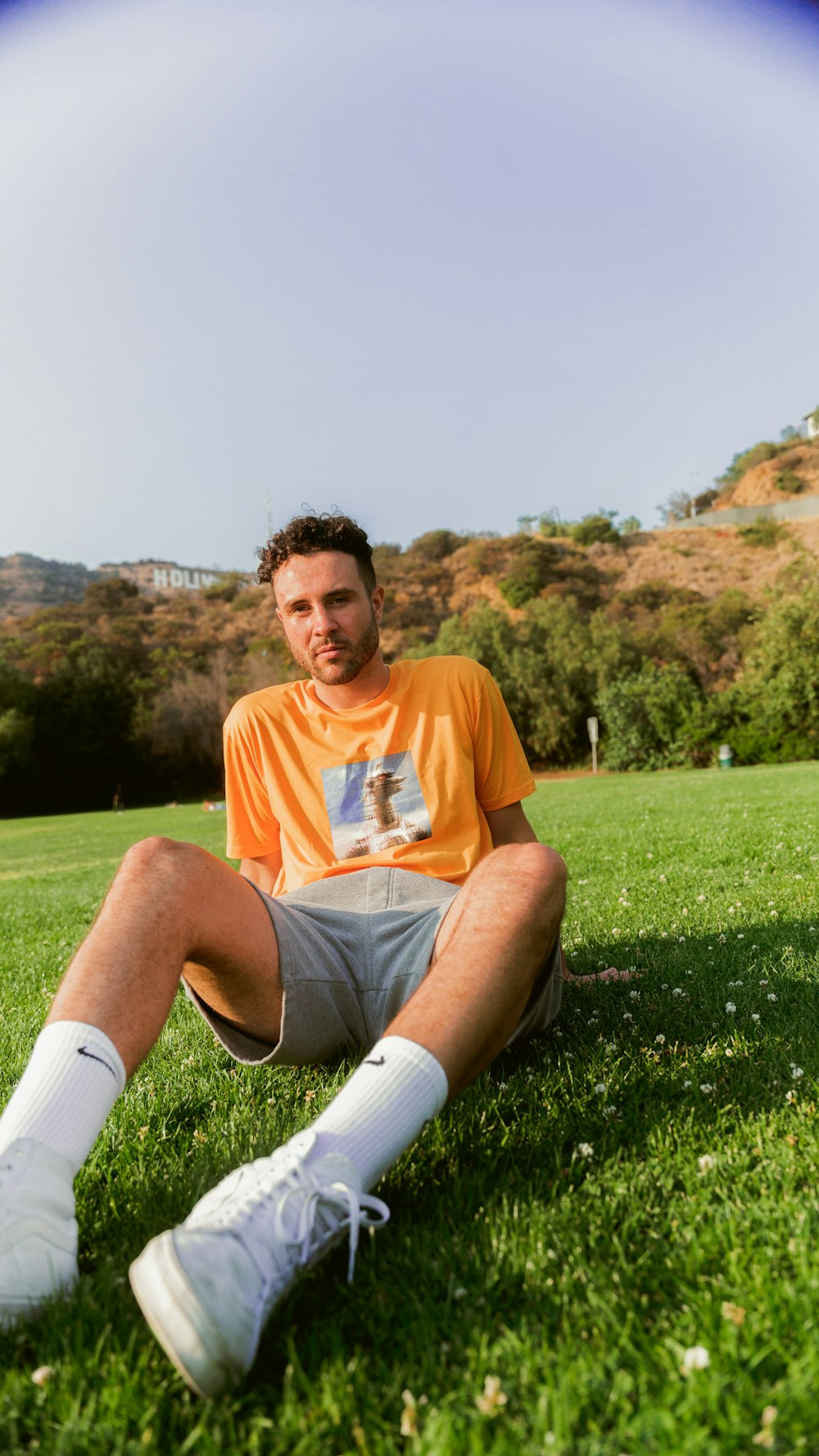 a man sitting in the grass with a frisbee