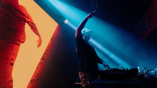 a dj performing in front of a large screen