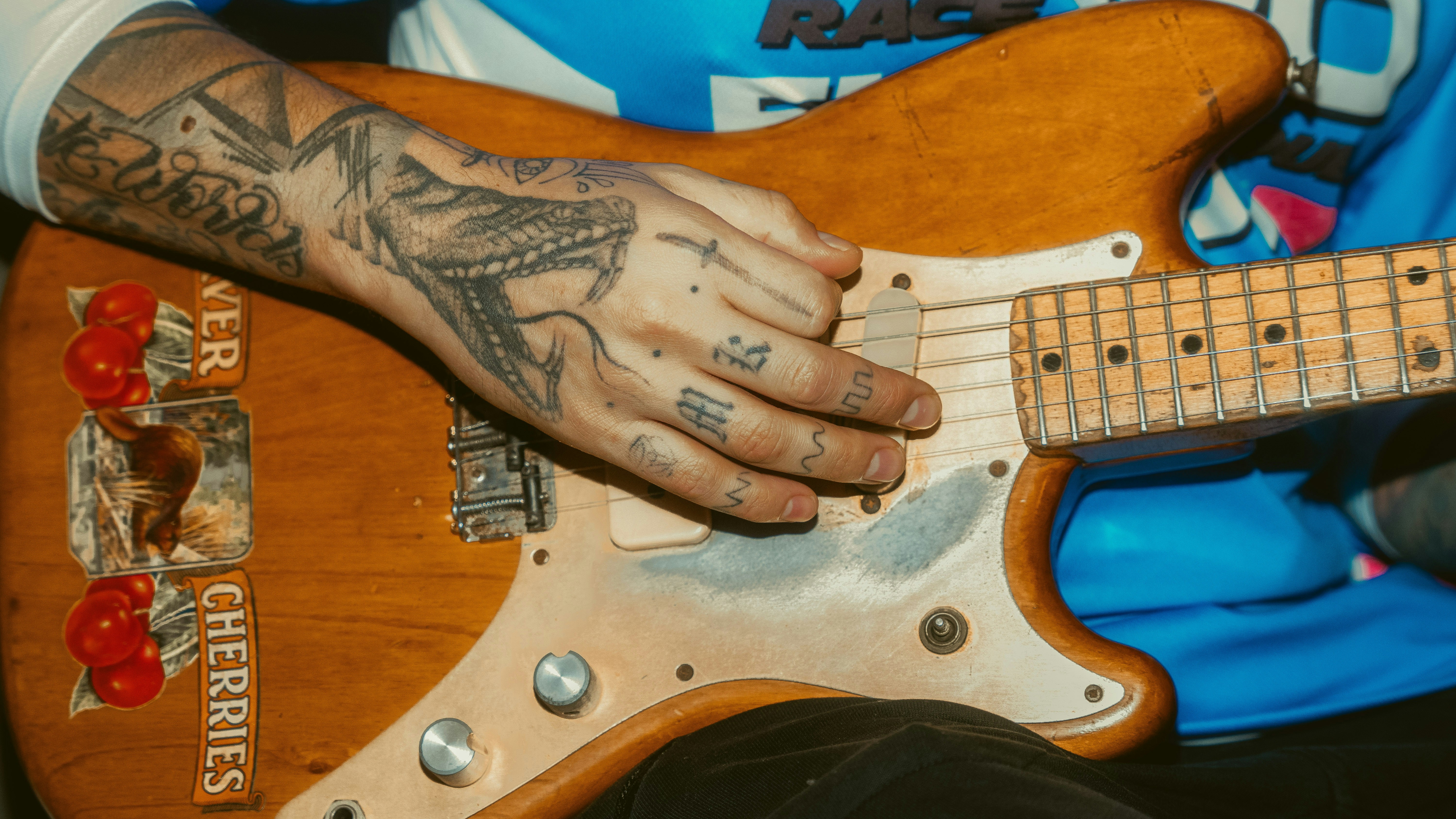 una persona con un tatuaje tocando una guitarra