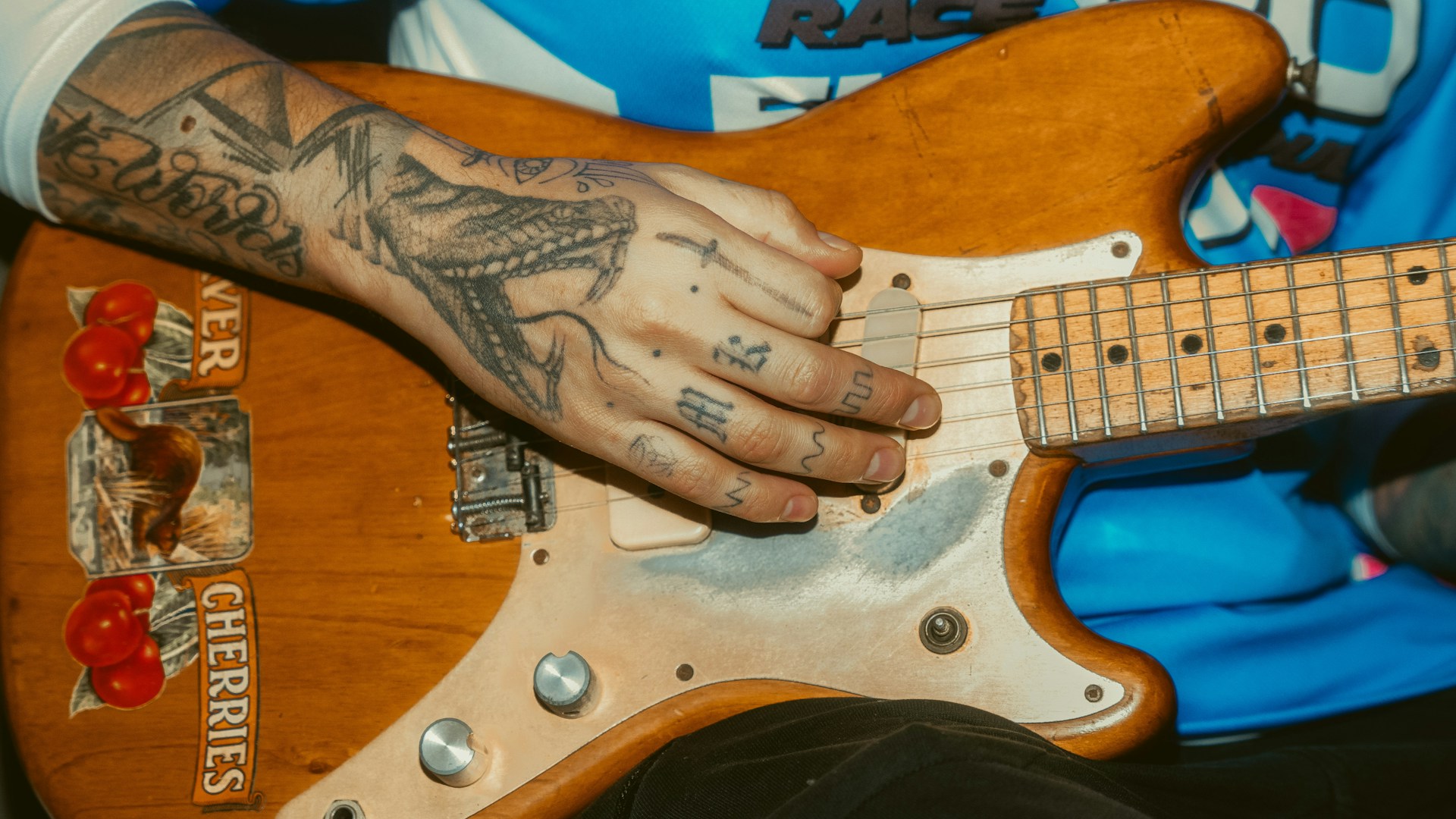 a person with a tattoo playing a guitar