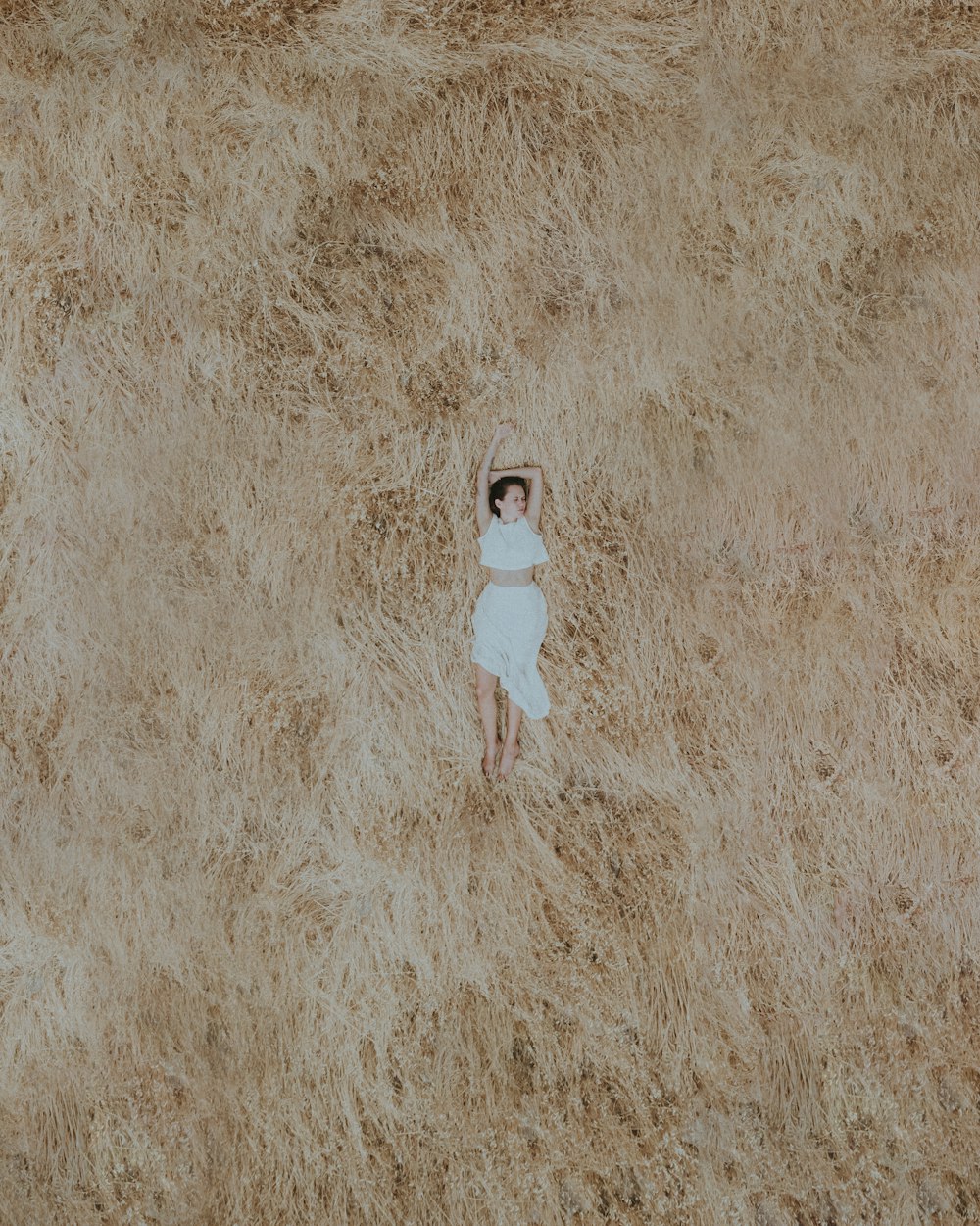 a woman in a white dress standing in a field