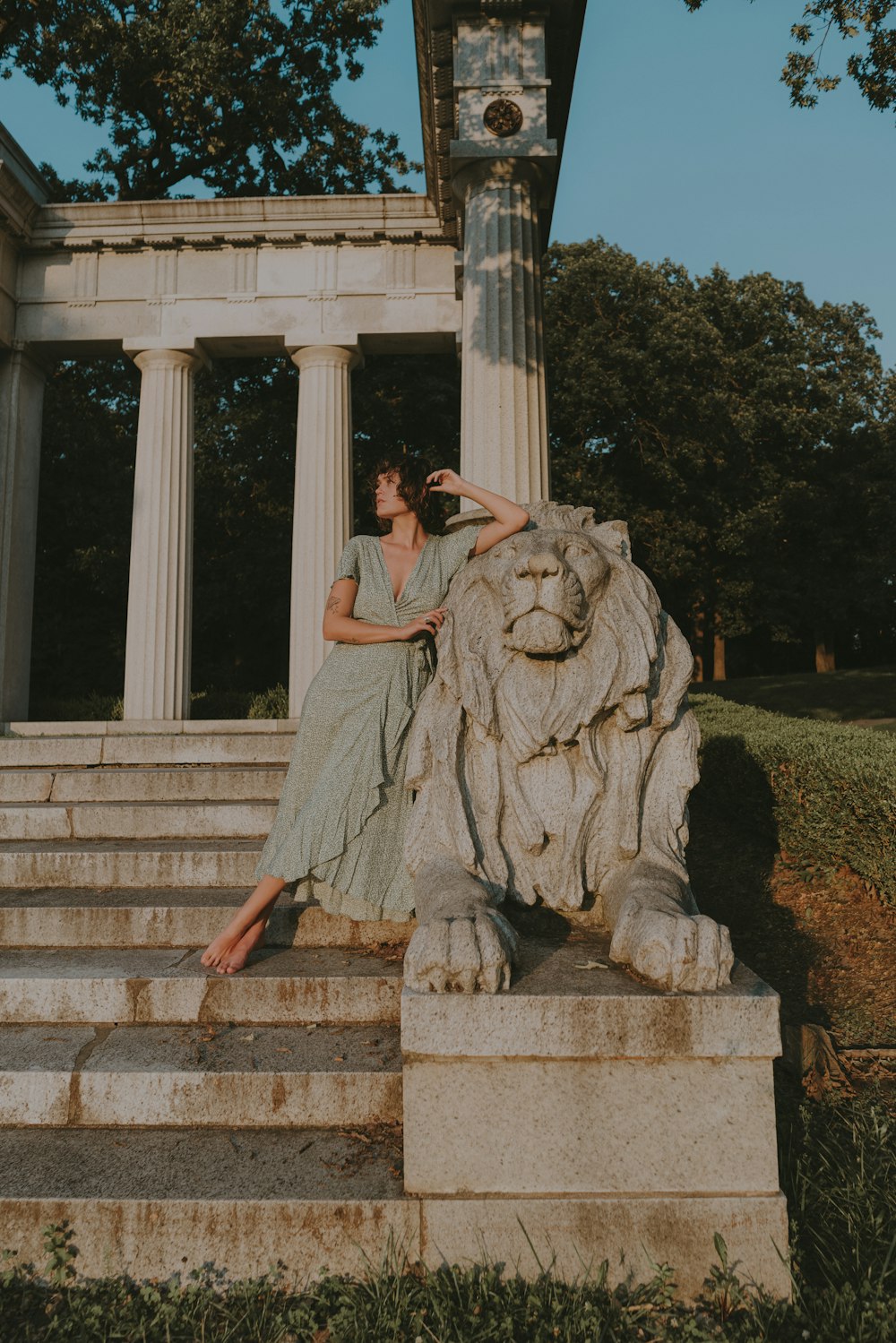 a woman sitting on a stone lion statue