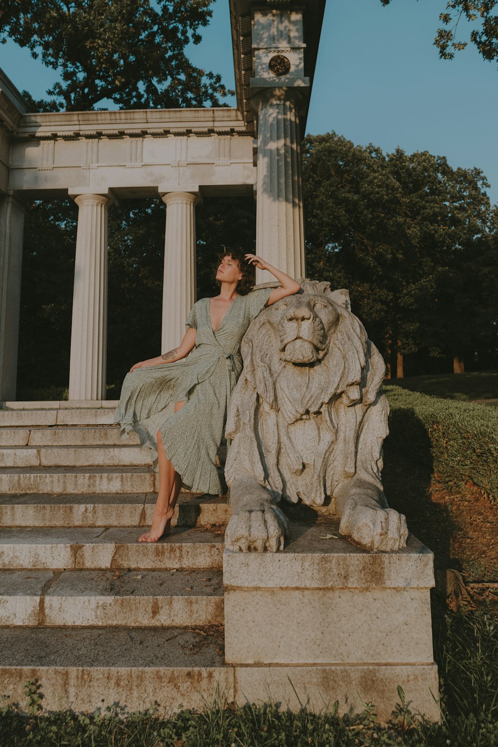 a woman sitting on a stone lion statue