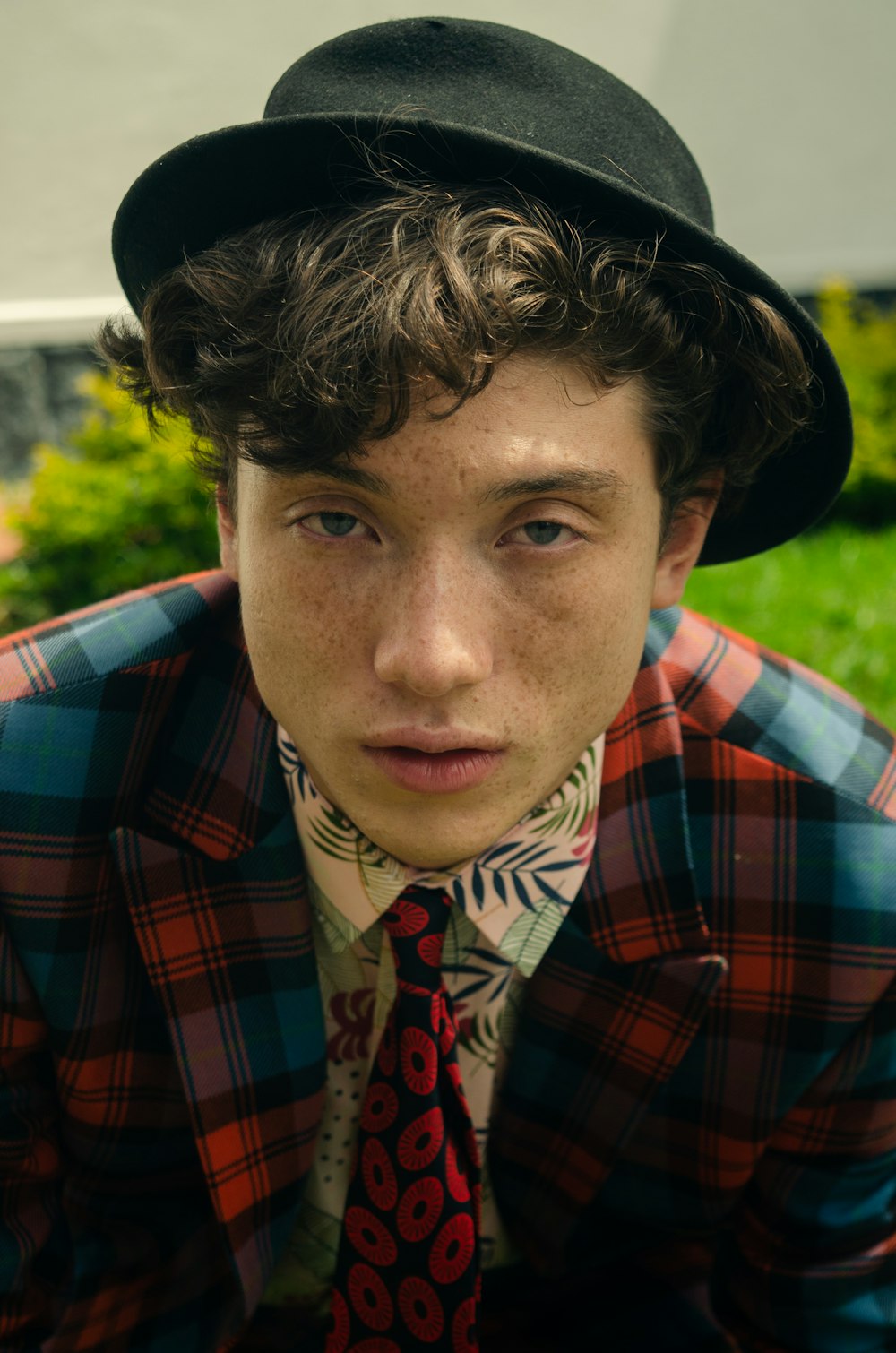 a young man wearing a hat and a tie