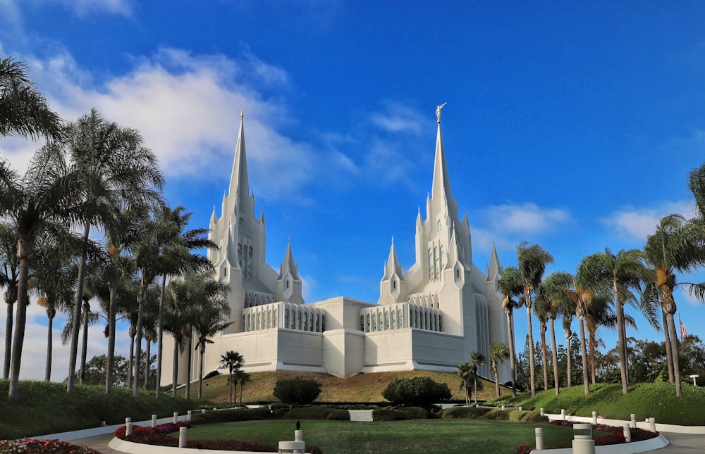 a large white church with palm trees in front of it