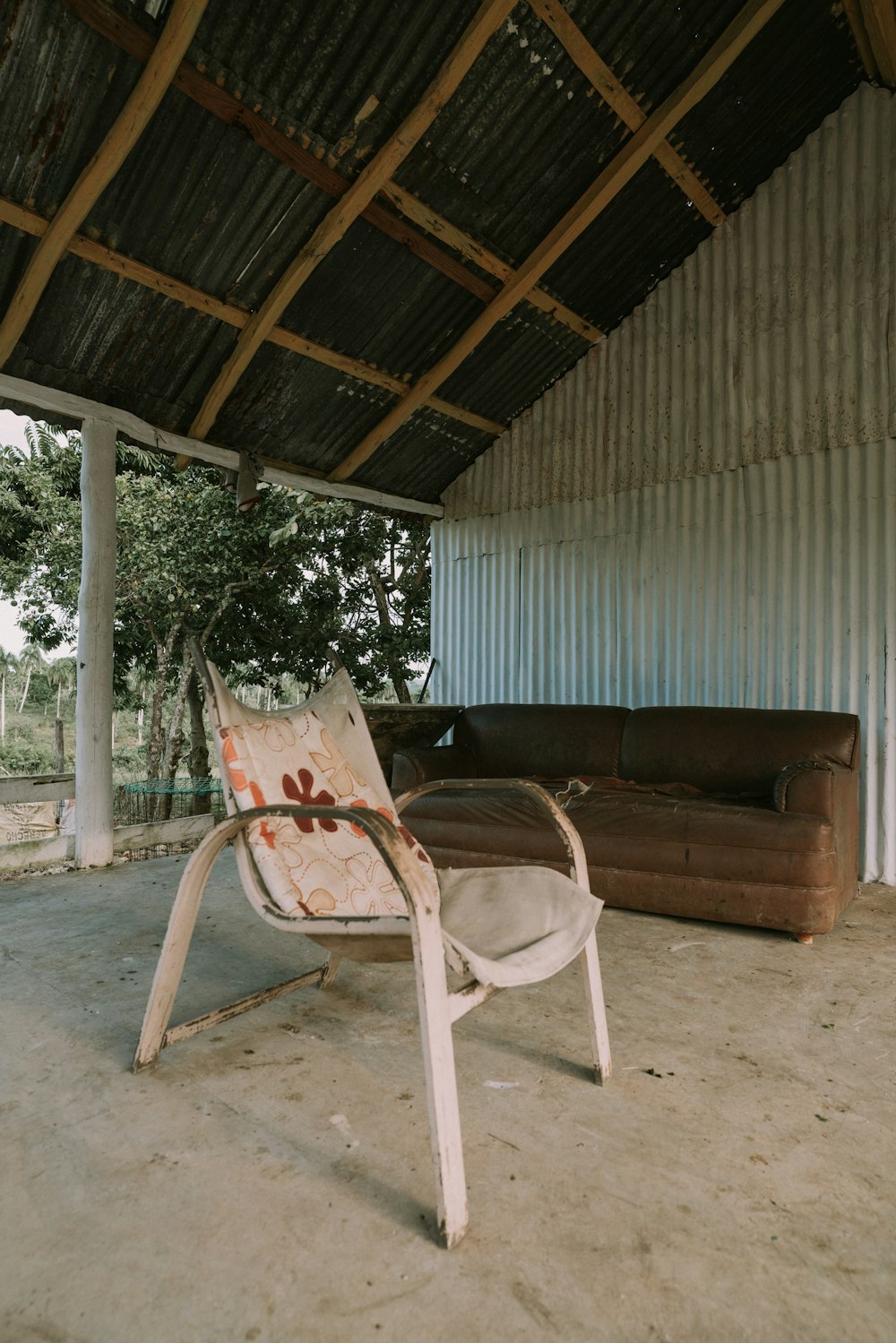 a chair and couch sitting under a roof