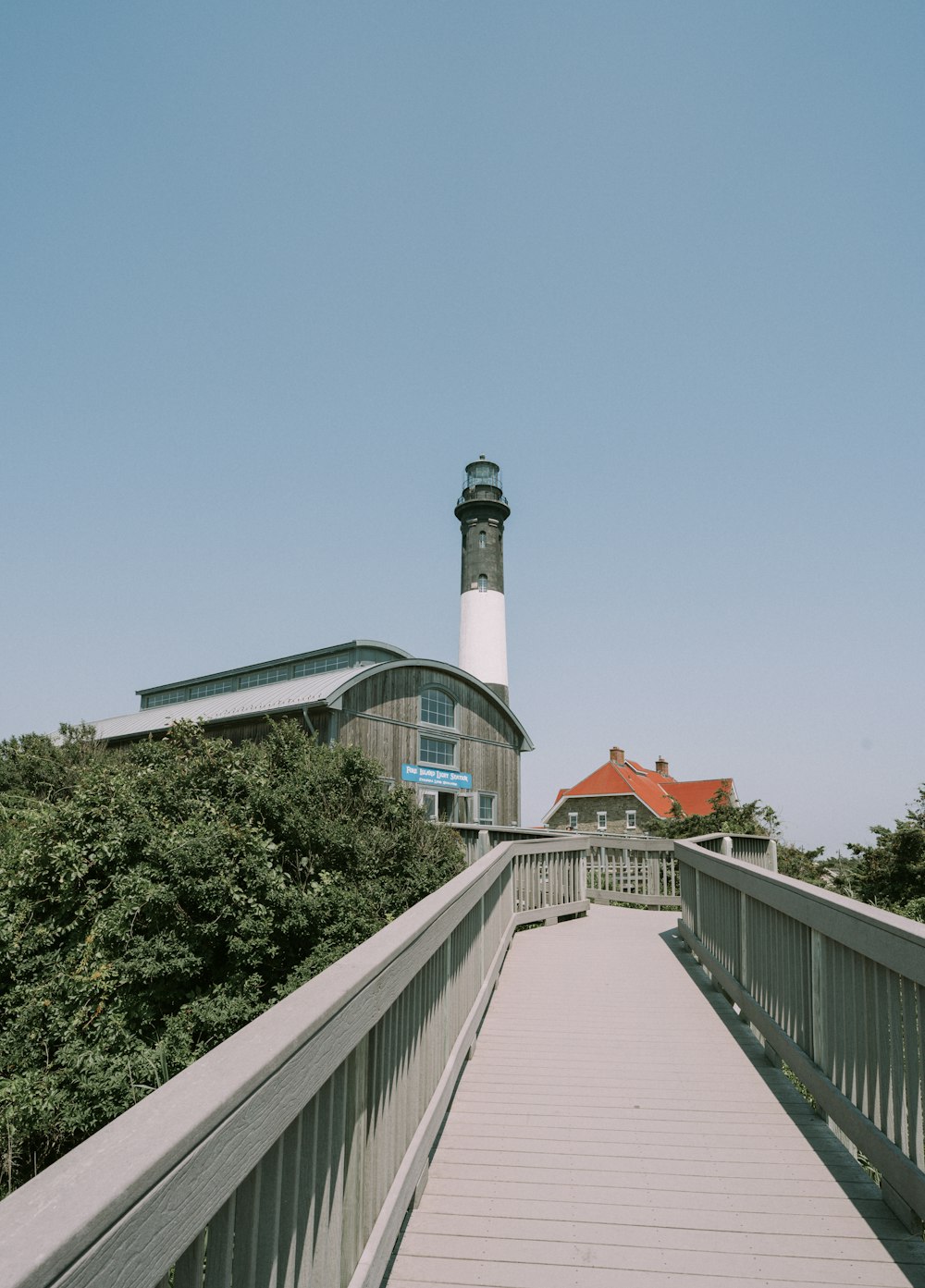 a walkway leading to a lighthouse on a clear day