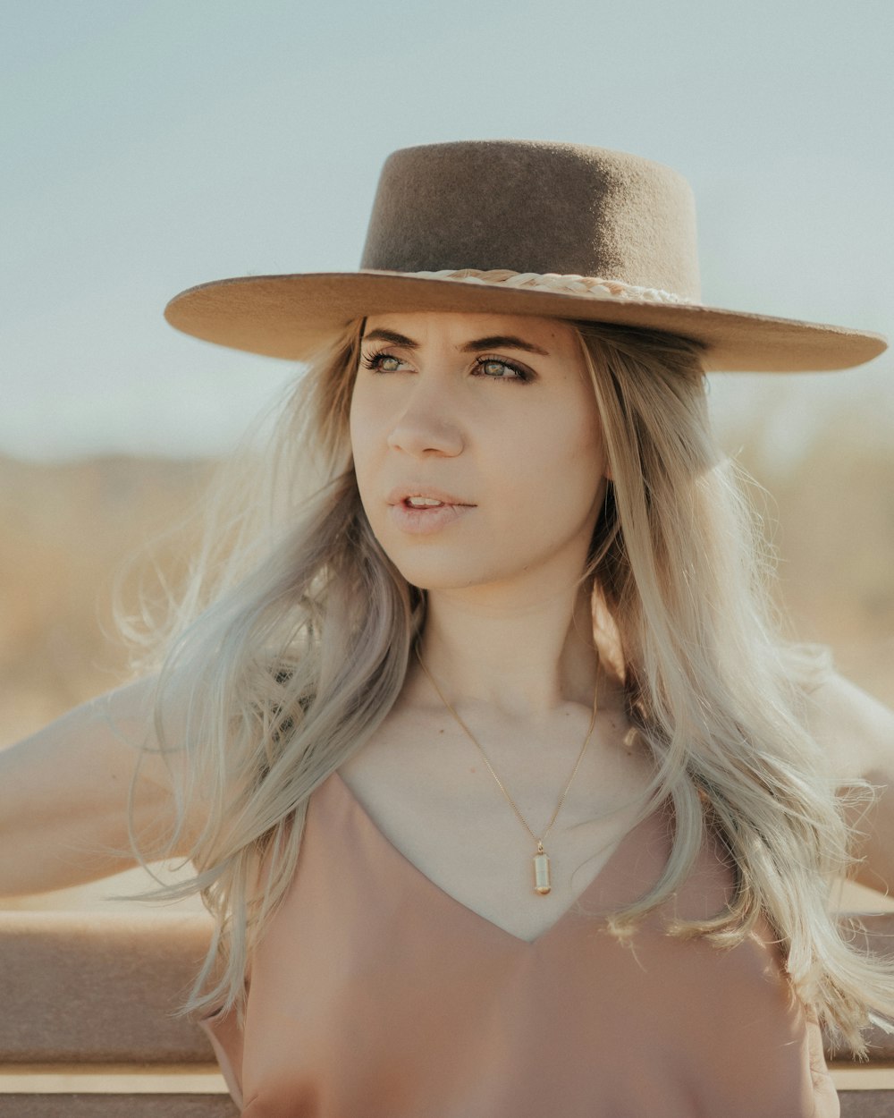 Una mujer con cabello largo y rubio con sombrero